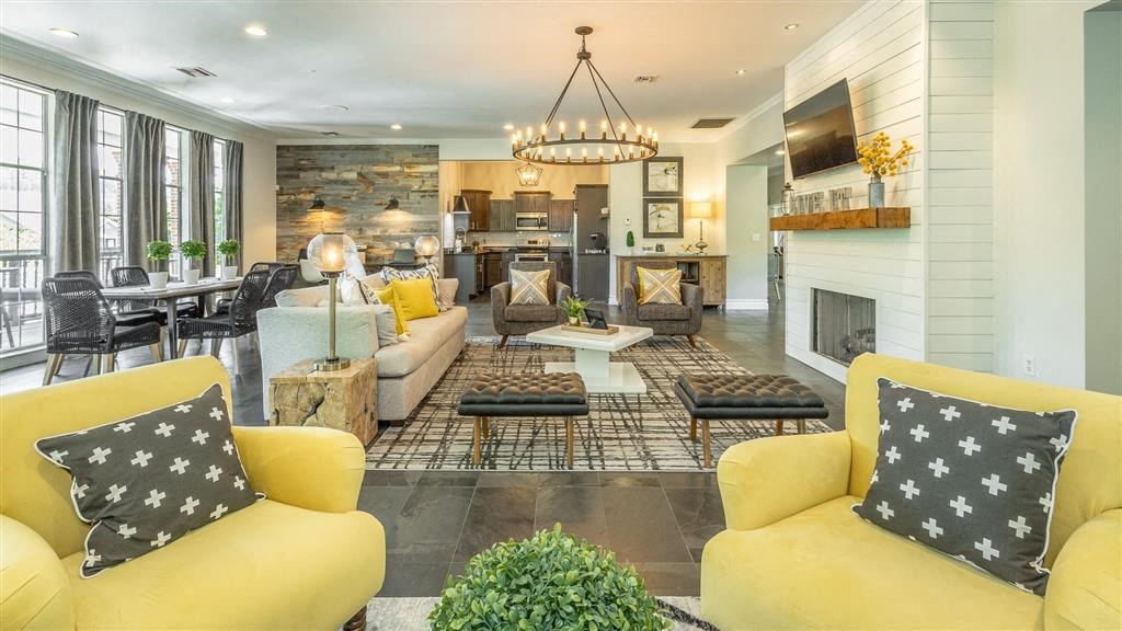 a living room with yellow couches and chairs and a fireplace