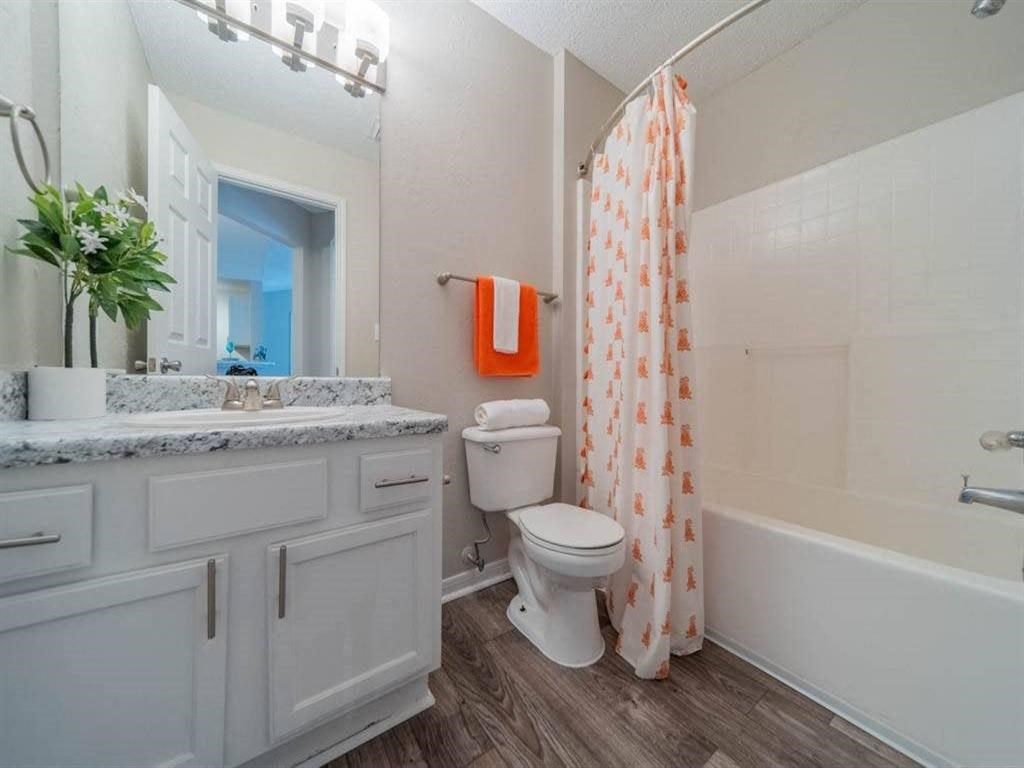 a bathroom with a shower and a toilet and a sink