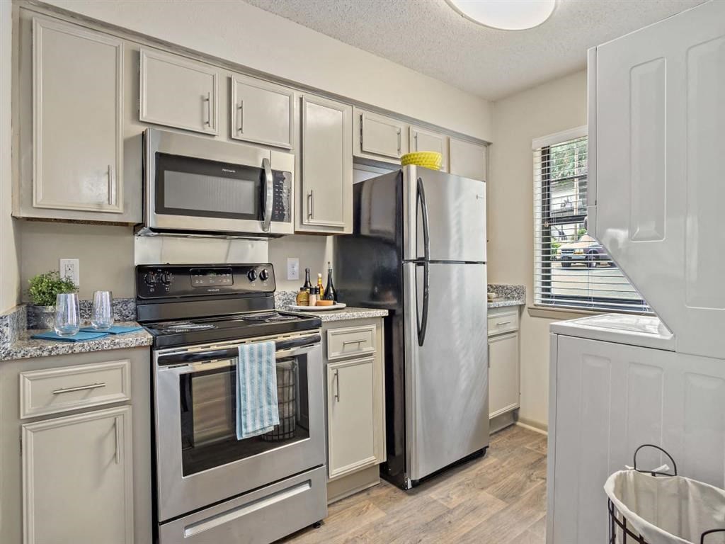 a kitchen with stainless steel appliances and white cabinets