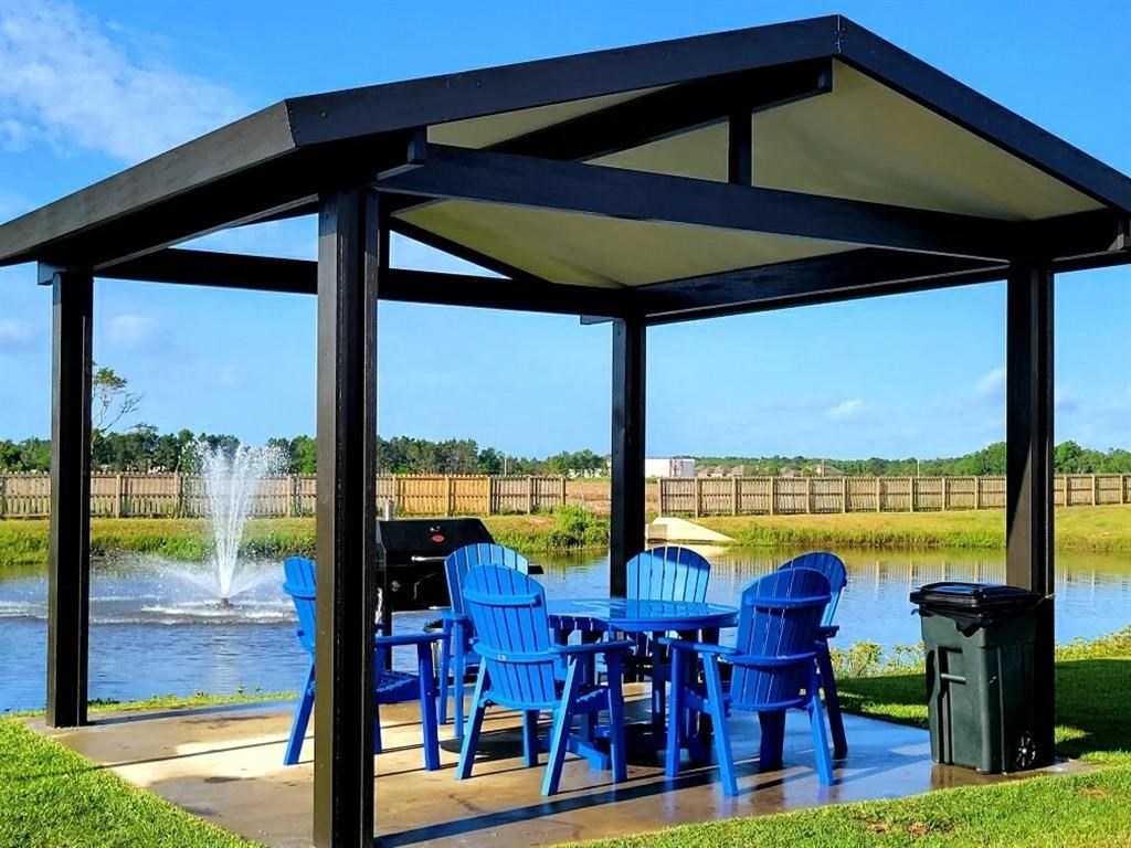 a patio with a table and chairs and a fountain