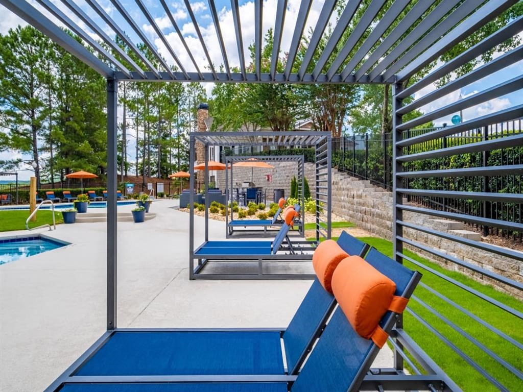 an outdoor lounge area with lounge chairs and a pool