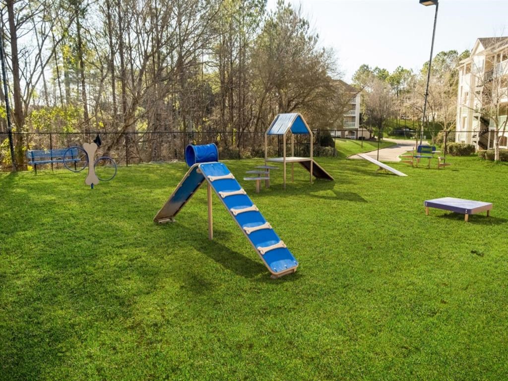 a playground with a slide and benches in a park