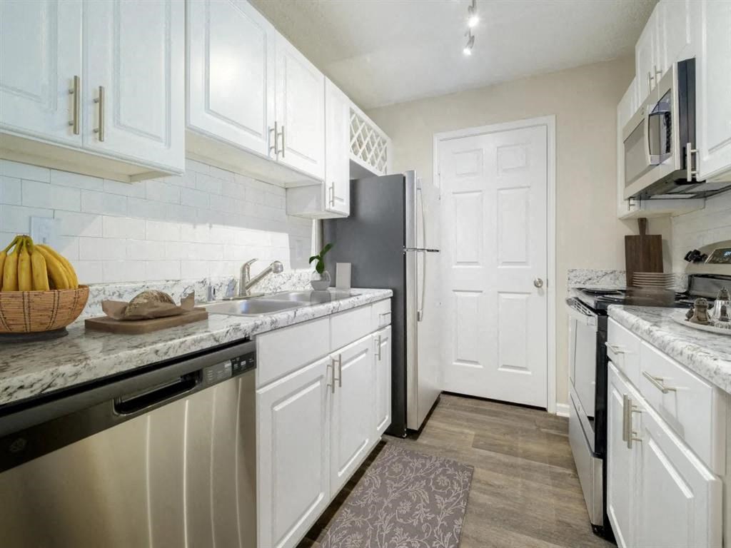 a kitchen with white cabinets and a black refrigerator