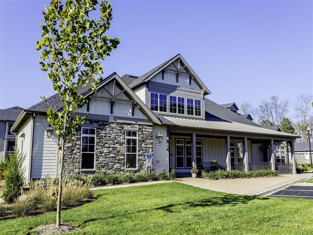 the exterior of a house with a lawn and a tree