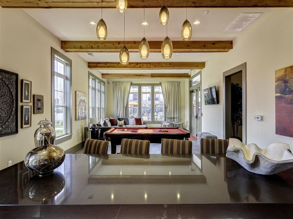 a large living room with a pool table in the middle