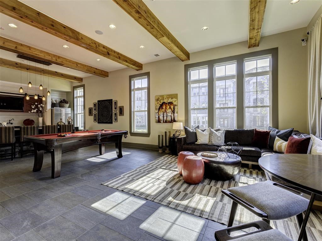 a game room with a pool table and couches