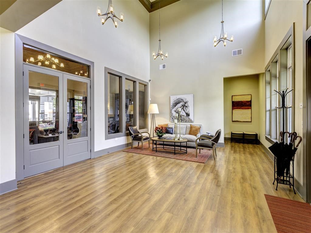 a living room with a couch and a table in front of mirrors