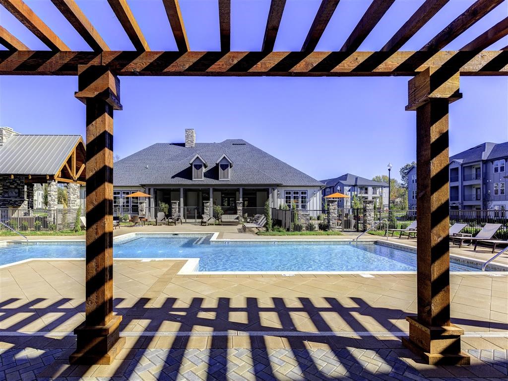 a large swimming pool with a house in the background