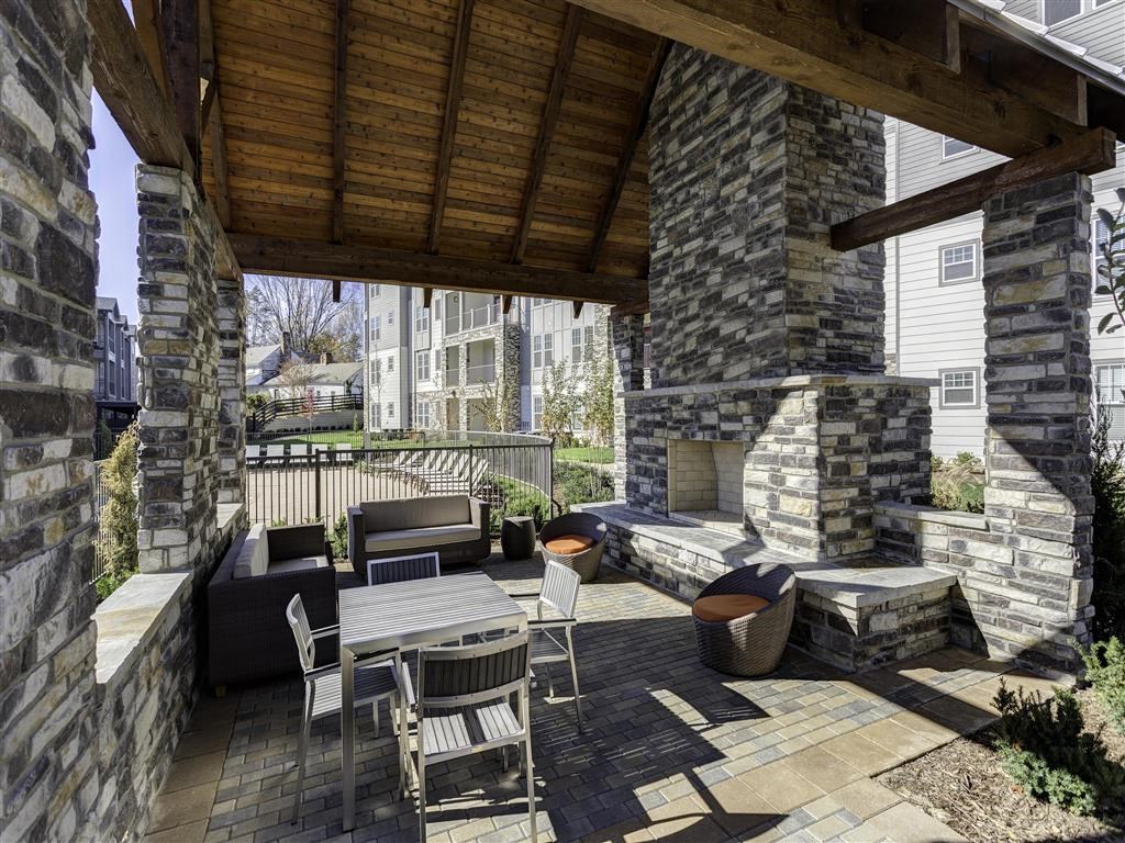 a patio with a table and chairs and a fireplace