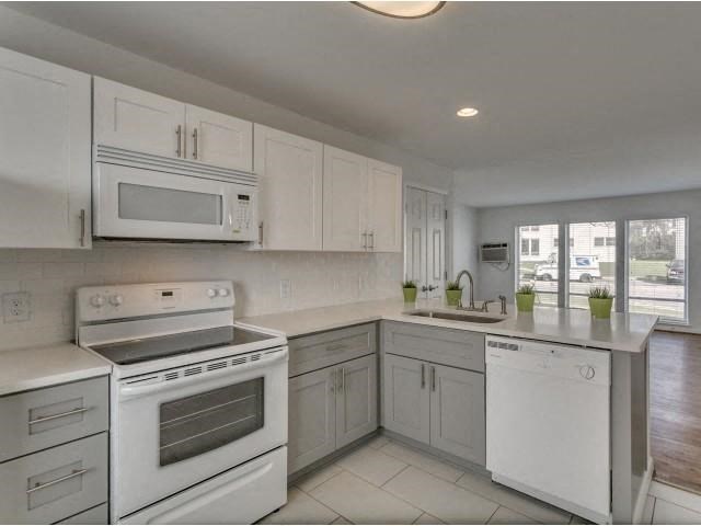 a white kitchen with a stove and a sink