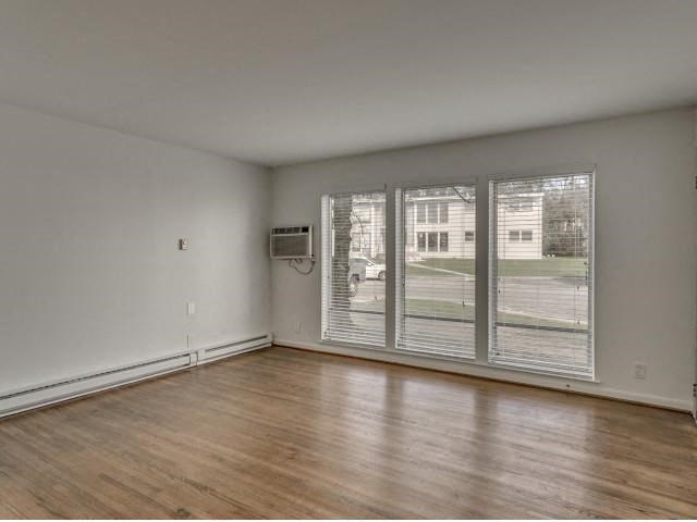 an empty living room with a large window and wooden floors