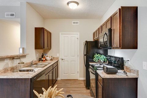 a kitchen with black appliances and brown cabinets