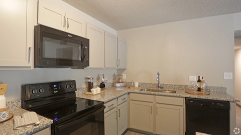 A kitchen with a black stove and microwave.