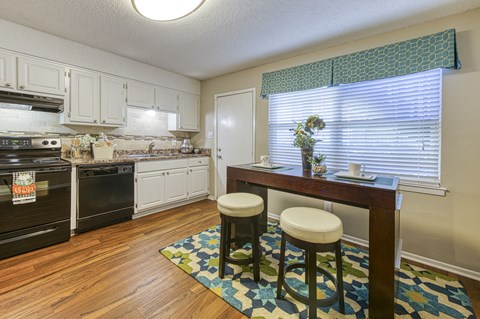 a kitchen with a table and stools in front of a window