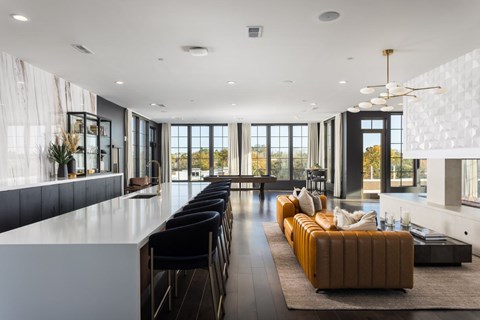 A modern living room with a long white sofa and a black counter.