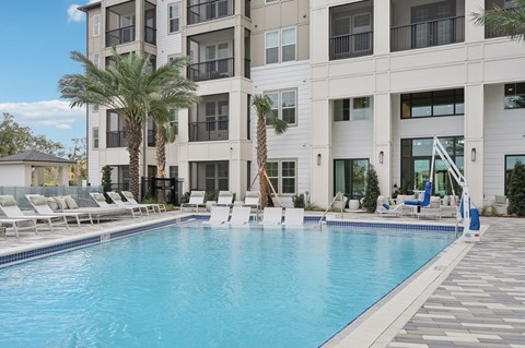 a large pool with sundeck, chaise lounges at Tapestry University Park Apartments in Sarasota, FL