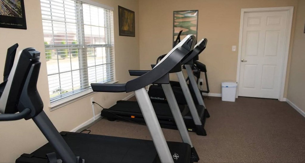 A room with treadmills and a window.