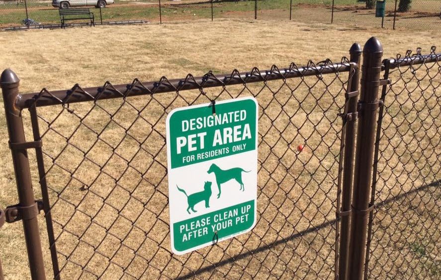 A sign on a fence designates the area as a pet-only zone.