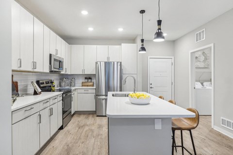 a large kitchen with white cabinets and stainless steel appliances