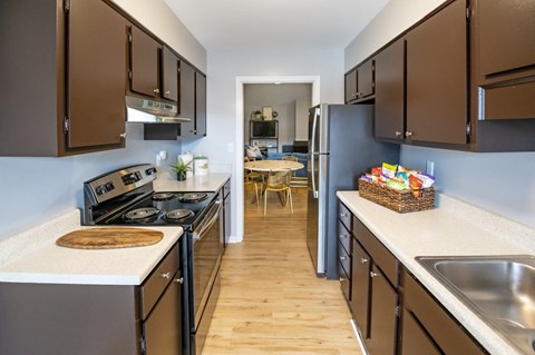 A kitchen with brown cabinets and a stove top oven.