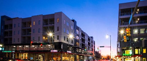 Mixed use development exterior at dusk with retail shops at Reserve on 3rd Apartments, Alabama