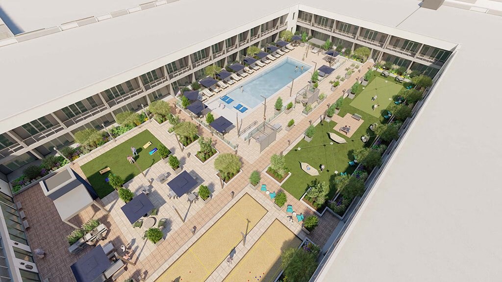 an overhead view of an apartment complex with a pool and lawn