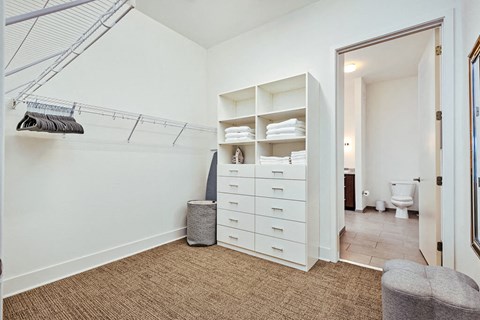 a white bathroom with a closet and a toilet