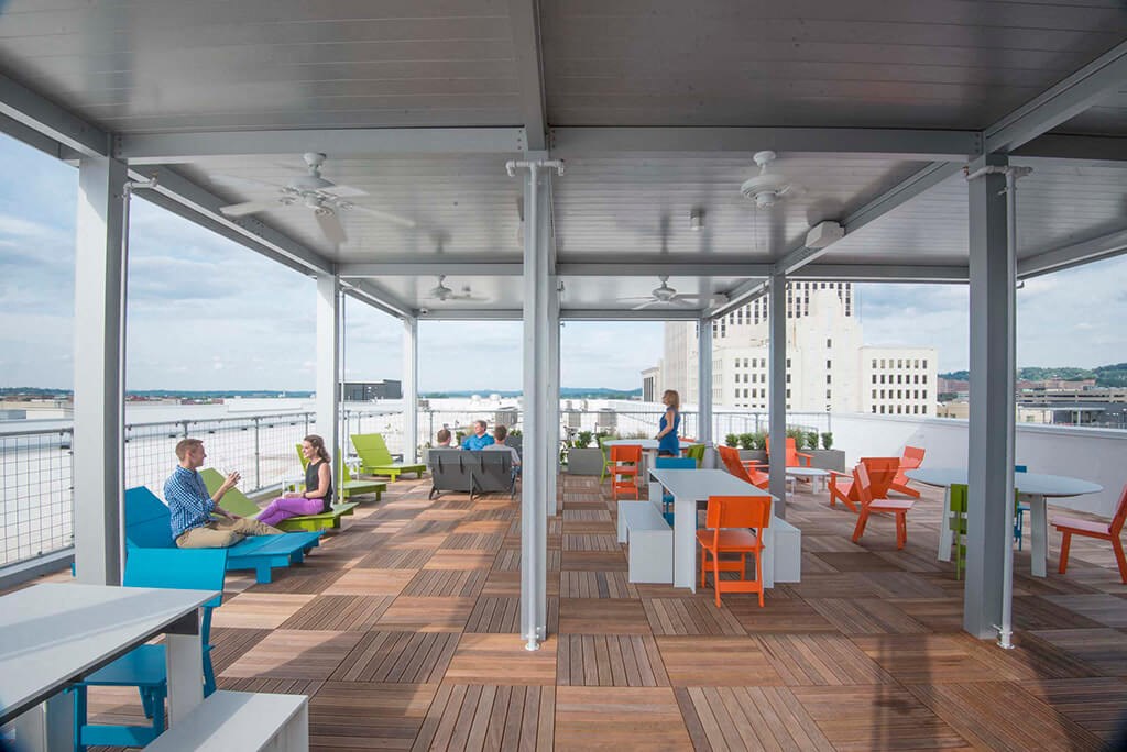 a large deck with tables and chairs and a view of the water