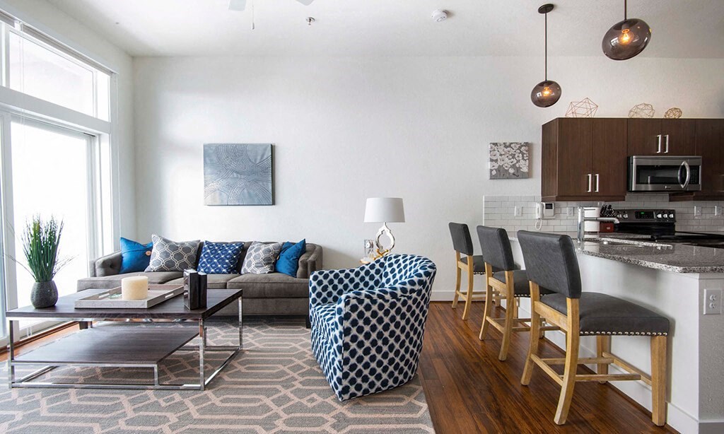 a living room and kitchen with a couch and a table