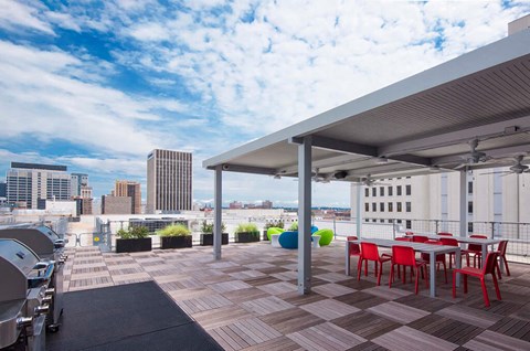 a rooftop patio with tables and chairs and a view of the city