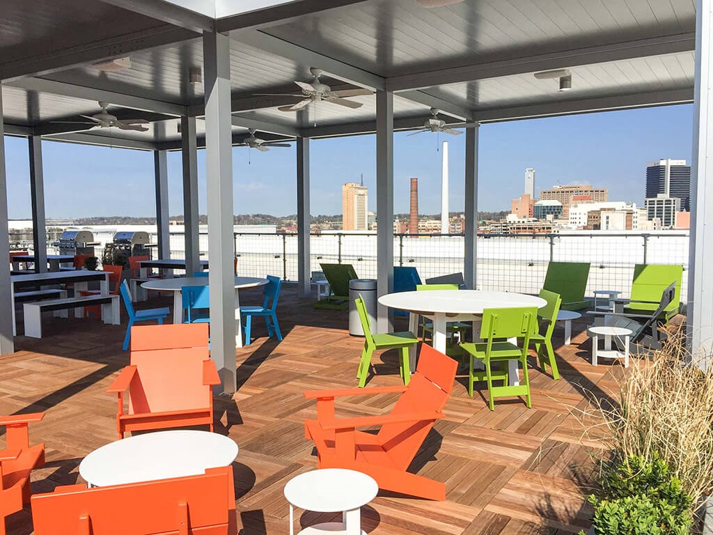 a patio with tables and chairs and a view of the water