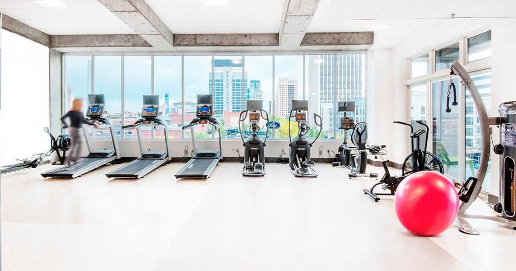 a large gym with cardio machines and a red ball