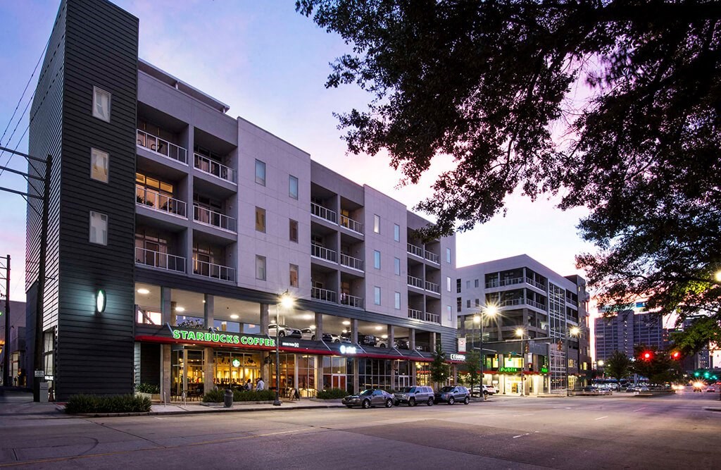 a street view of an apartment building at dusk