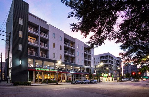 a street view of an apartment building at dusk