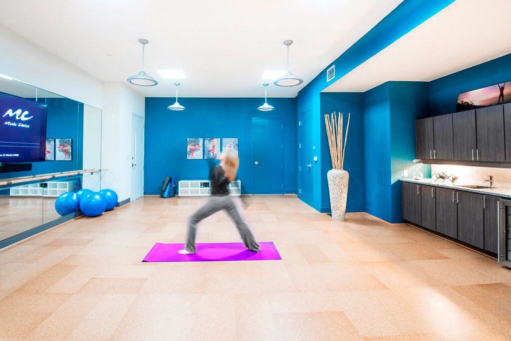 a woman doing yoga on a purple yoga mat in a lobby