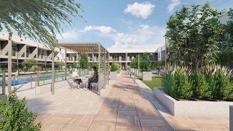 two people sitting at a table on a patio near a pool