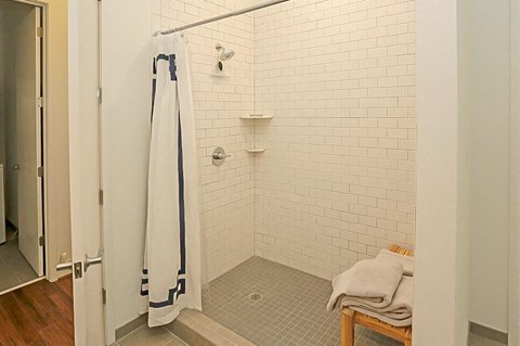 a bathroom with a shower with a white shower curtain
