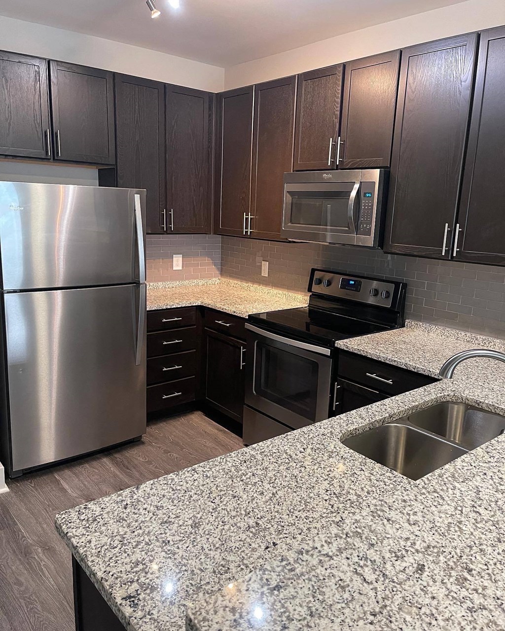 Kitchen with espresso cabinets, double sinks at Flats on 4th Apartments in Birmingham, AL