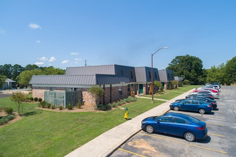 a parking lot filled with cars in front of a building