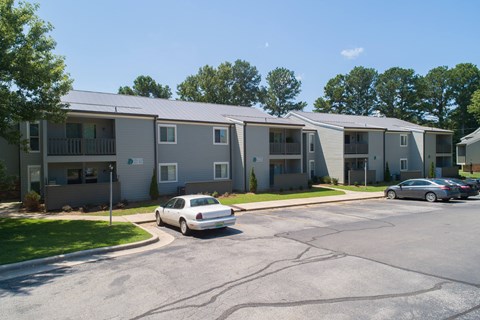 an apartment building with cars parked in front of it