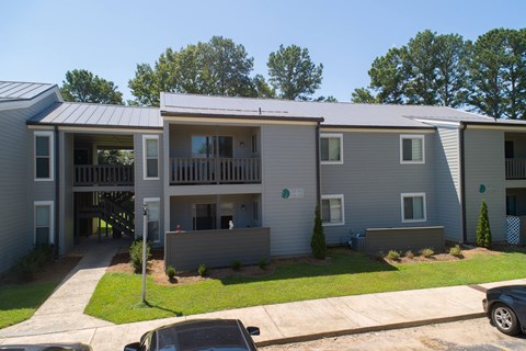an image of an apartment building with cars parked in front