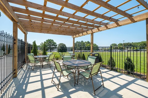 a patio with tables and chairs and a pergola
