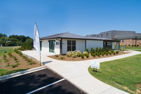 a small white building with a sign in front of it