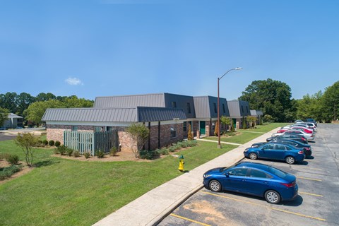a parking lot filled with cars in front of a building
