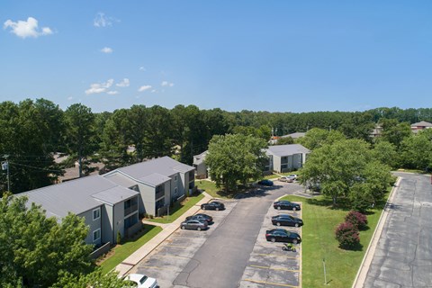 an aerial view of an apartment complex with cars parked on the street