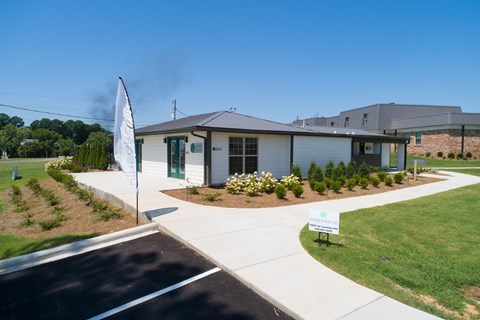 a small white house with a sign in front of it