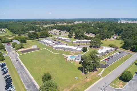 a view from the sky of a neighborhood with cars parked in a field