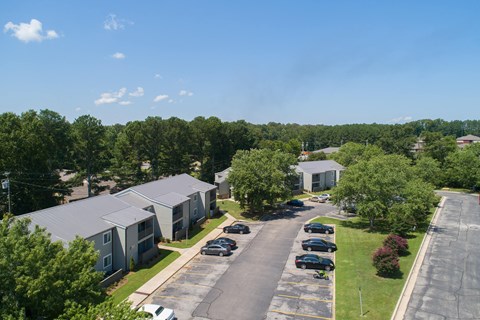 an aerial view of an apartment complex with cars parked on the street