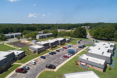 an aerial view of a parking lot with buildings and cars