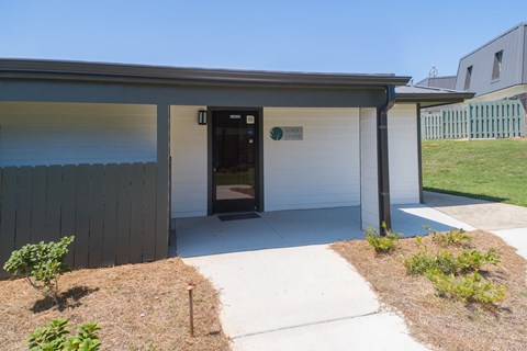 the front entrance of a white house with a black door